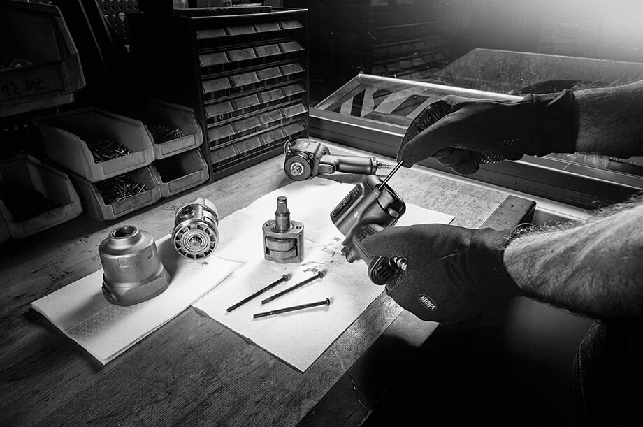 Am Tisch wird ein Produkt zusammengebaut.